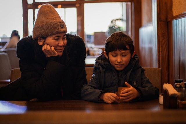 A mother and her son sitting together at a table